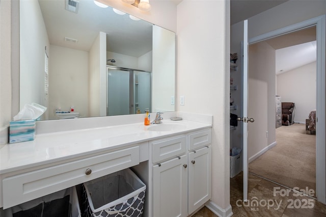 ensuite bathroom with visible vents, vanity, a shower stall, and ensuite bathroom