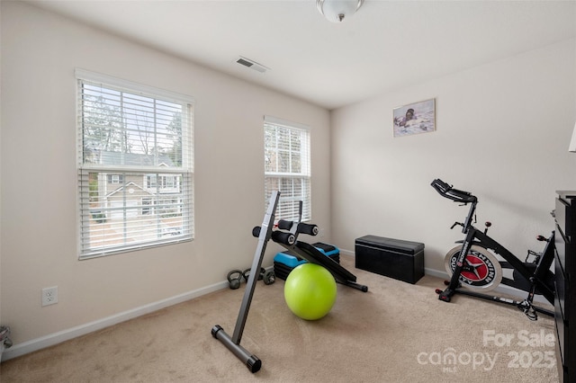 workout area featuring baseboards, visible vents, and carpet flooring