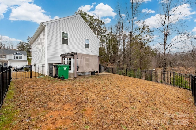 back of property with a fenced backyard, a yard, and a pergola