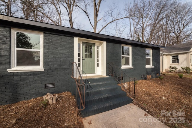 view of front of house featuring brick siding and crawl space