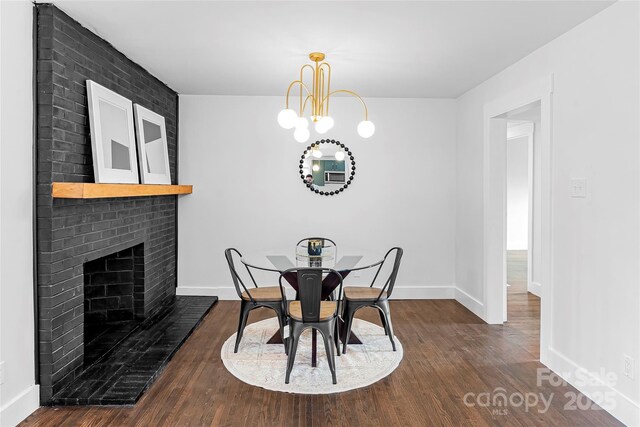 5825 Ruth Dr, Charlotte, NC 28215 - dining space with baseboards, dark wood-type flooring, a fireplace, and a notable chandelier