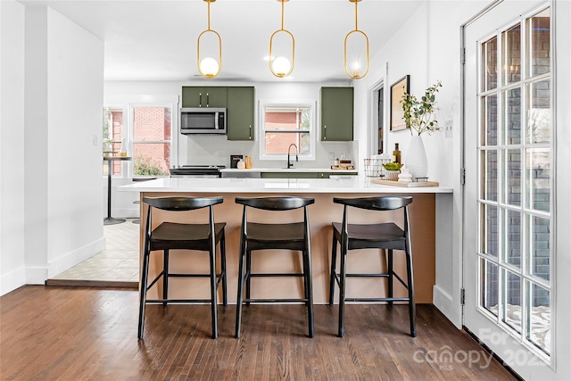 5825 Ruth Dr, Charlotte, NC 28215 - kitchen with a sink, appliances with stainless steel finishes, backsplash, and green cabinetry