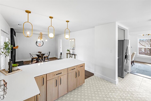 5825 Ruth Dr, Charlotte, NC 28215 - kitchen with pendant lighting, a peninsula, light countertops, and stainless steel fridge with ice dispenser