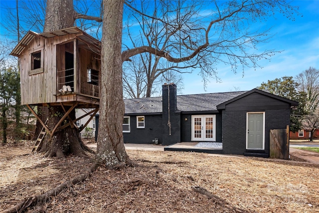 5825 Ruth Dr, Charlotte, NC 28215 - rear view of property featuring a shingled roof, a chimney, french doors, a patio area, and brick siding