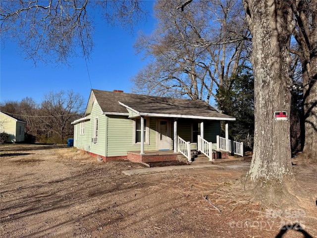 view of front of home with a porch and roof with shingles