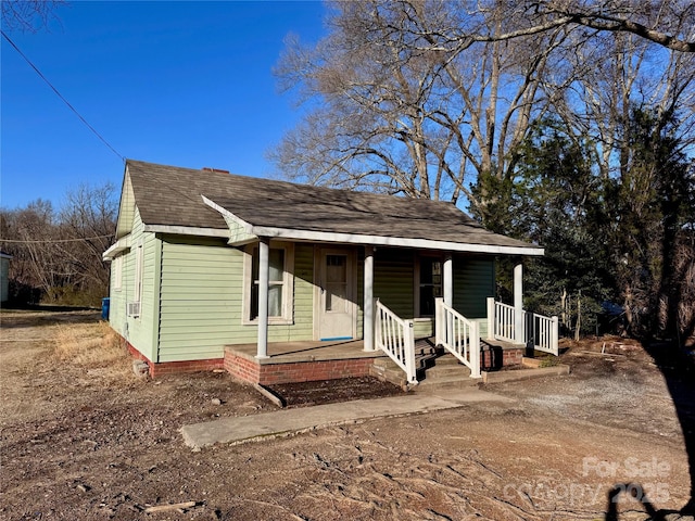 view of front facade with covered porch and roof with shingles