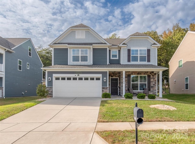 craftsman-style house featuring a front lawn, driveway, and an attached garage