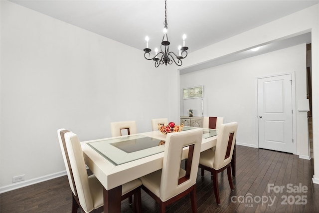 dining room featuring dark wood-style flooring, baseboards, and a chandelier