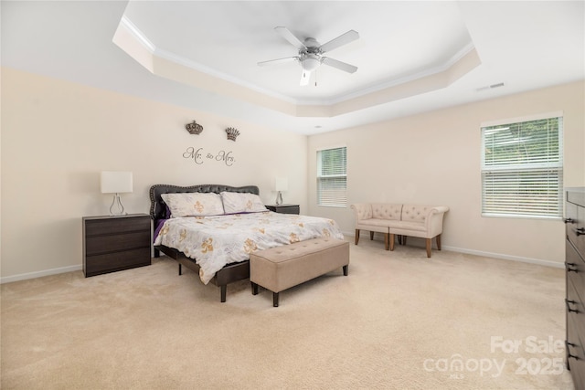 bedroom featuring baseboards, crown molding, a tray ceiling, and light colored carpet