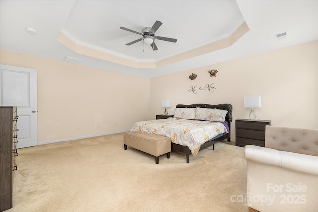 bedroom with visible vents, baseboards, crown molding, light colored carpet, and a tray ceiling