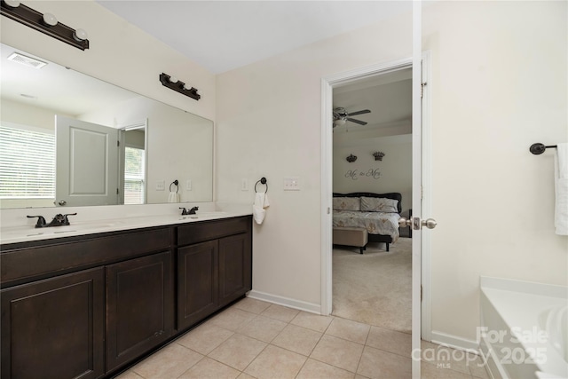 full bathroom with a sink, tile patterned floors, double vanity, and ensuite bath