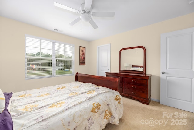 bedroom featuring visible vents, light colored carpet, and a ceiling fan