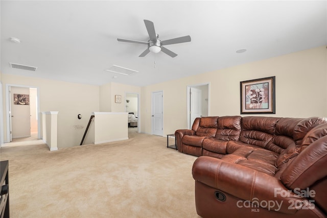 living area featuring attic access, visible vents, and light carpet