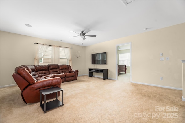 living room with light colored carpet, a ceiling fan, and baseboards