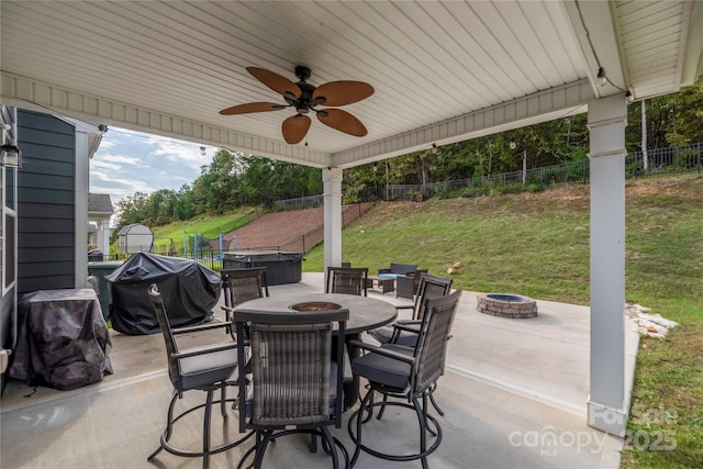 view of patio featuring a fire pit, area for grilling, a ceiling fan, and a fenced backyard