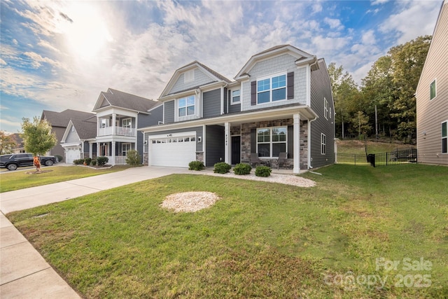 craftsman house with a front yard, driveway, covered porch, an attached garage, and fence