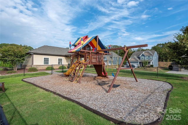 community play area with a lawn and fence