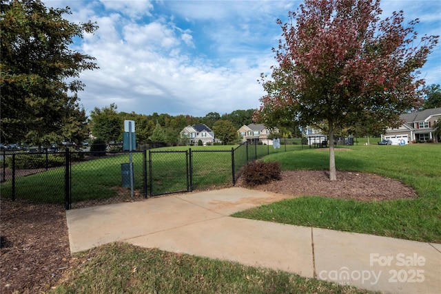 view of gate featuring fence and a lawn