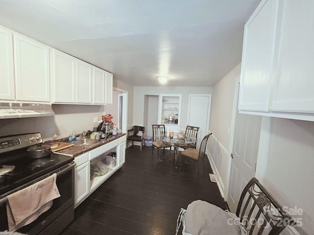 kitchen with dark countertops, electric stove, white cabinetry, dark wood-style flooring, and under cabinet range hood