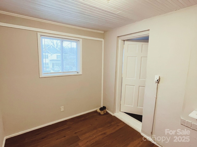 unfurnished room with baseboards and dark wood-style flooring