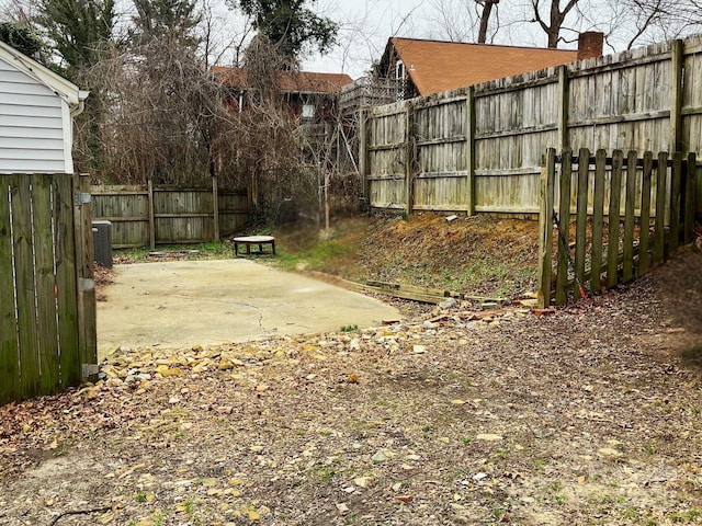 view of yard featuring central AC unit, a patio area, and fence