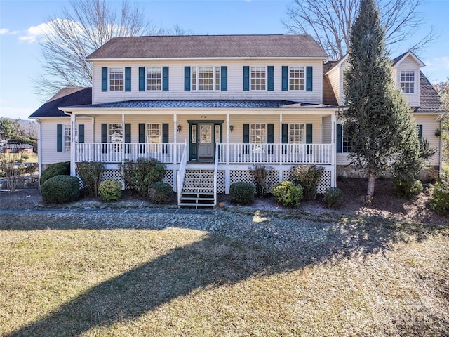 colonial home featuring a porch and a front lawn