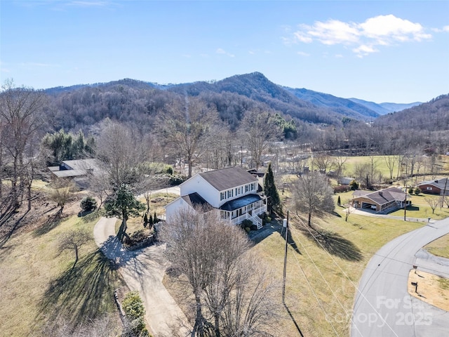 birds eye view of property featuring a mountain view and a view of trees