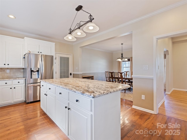 kitchen featuring white cabinets, light stone counters, a center island, light wood-style floors, and stainless steel refrigerator with ice dispenser