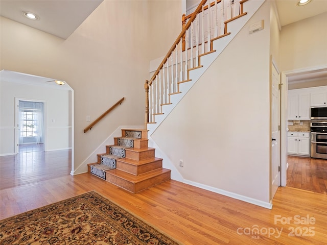 staircase with baseboards and wood finished floors