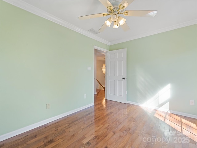 unfurnished room featuring baseboards, wood finished floors, a ceiling fan, and crown molding