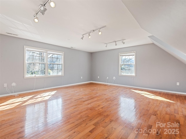 bonus room featuring lofted ceiling, light wood-style flooring, visible vents, and baseboards