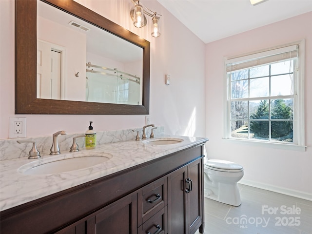 full bath featuring a stall shower, visible vents, a sink, and double vanity