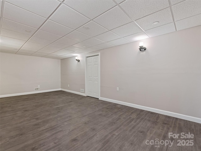 finished basement with dark wood-type flooring, a drop ceiling, and baseboards