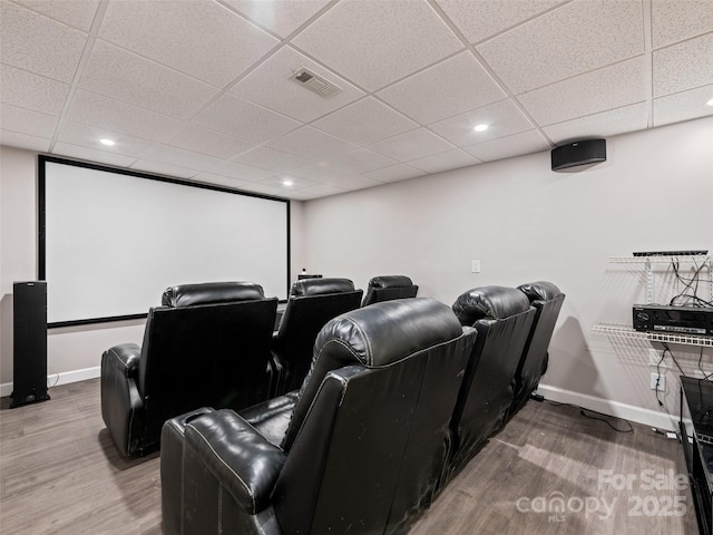 cinema with visible vents, a drop ceiling, baseboards, and wood finished floors