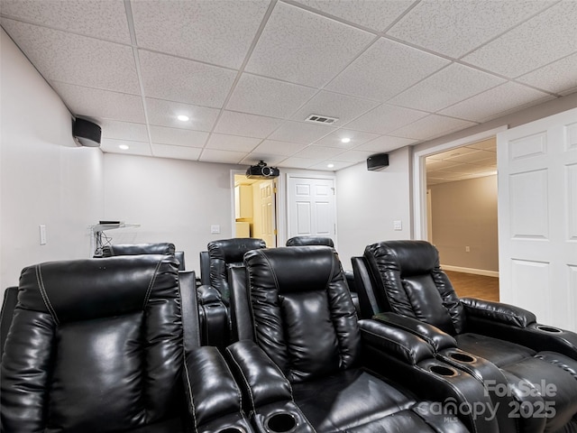 home theater room featuring baseboards, visible vents, a drop ceiling, and recessed lighting