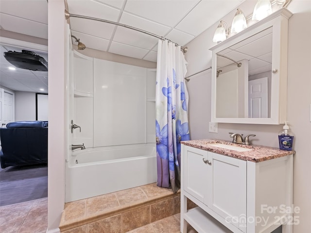 full bathroom featuring shower / bath combination with curtain, ensuite bathroom, vanity, a drop ceiling, and tile patterned floors