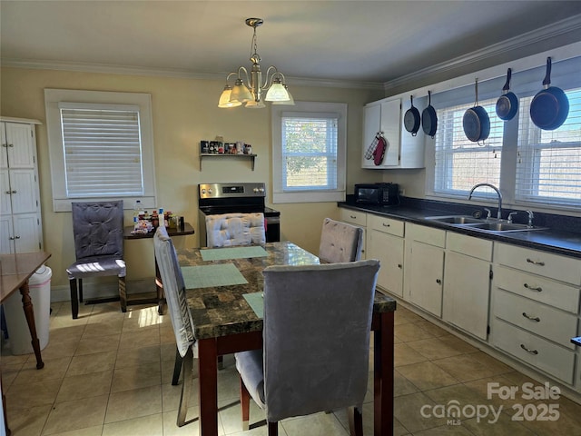 kitchen featuring dark countertops, stainless steel range with electric stovetop, white cabinetry, and a sink