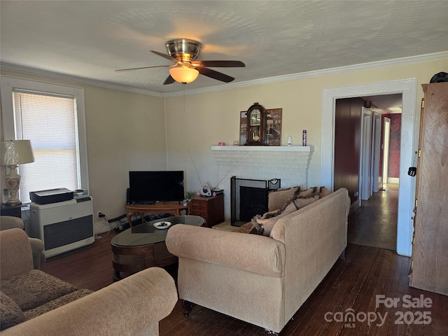 living room featuring a brick fireplace, dark wood-style floors, a ceiling fan, and ornamental molding