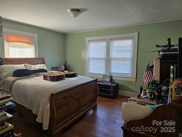 bedroom with dark wood-style flooring and baseboards