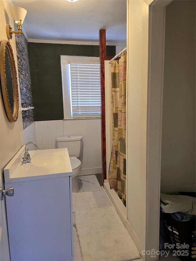 full bathroom with toilet, a shower with curtain, a wainscoted wall, marble finish floor, and vanity