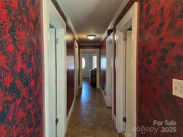 hallway with ornamental molding and baseboards