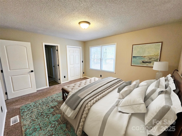 carpeted bedroom with visible vents, a textured ceiling, and baseboards