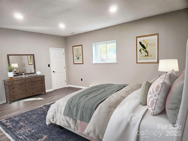 bedroom with baseboards, wood finished floors, and recessed lighting