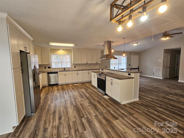 kitchen with visible vents, island range hood, appliances with stainless steel finishes, dark wood-style flooring, and backsplash