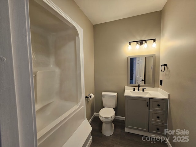 full bath with baseboards, vanity, toilet, and wood finished floors