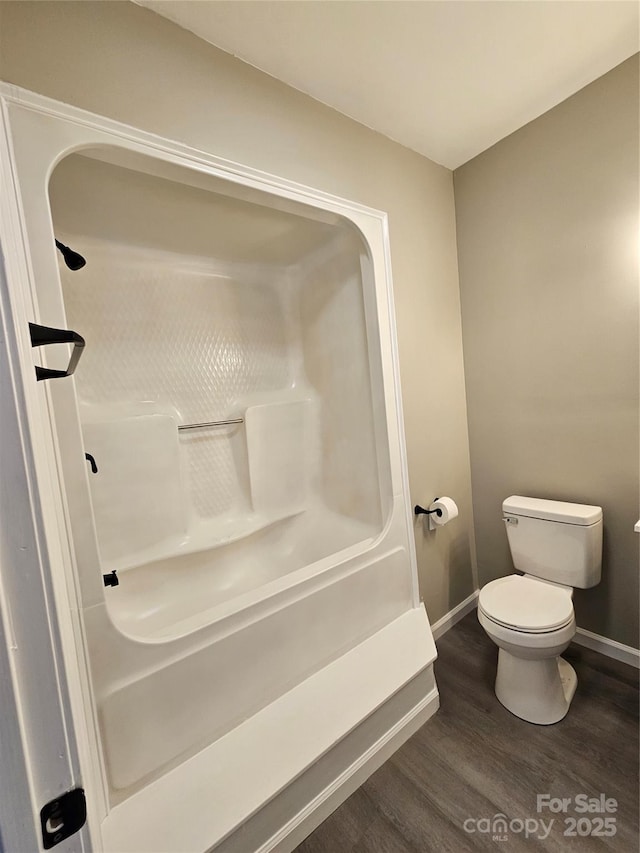 full bathroom with baseboards, toilet, and wood finished floors