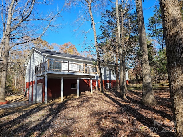 back of house with an attached garage and a deck