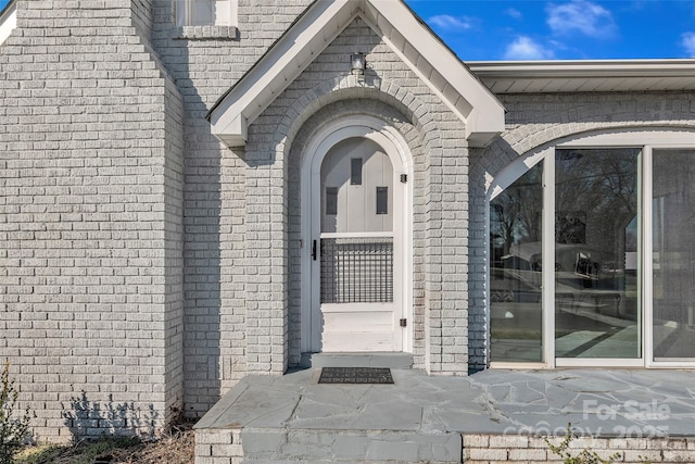 doorway to property featuring brick siding