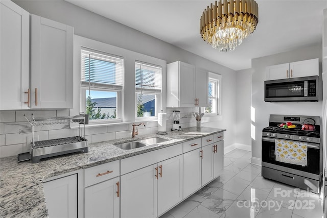 kitchen featuring a sink, stainless steel appliances, backsplash, and marble finish floor