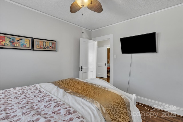 bedroom featuring wood finished floors, a textured ceiling, ceiling fan, and ornamental molding